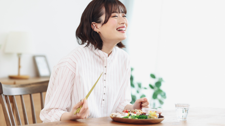 歯周病を改善し美味しく食事をする女性